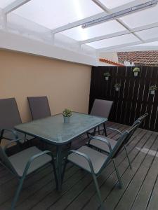 a patio table and chairs on a deck at Casa Avó Maria in Lourinhã