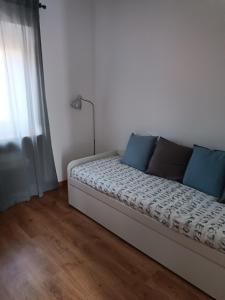 łóżko z niebieskimi poduszkami w pokoju w obiekcie Casa Avó Maria w mieście Lourinhã