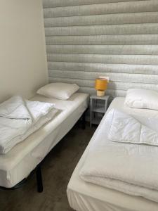 two beds in a room with a lamp on a table at Charming eco-lodge with heated pool and jacuzzi all year round in Charente-Marit in Les Mathes +14 photos