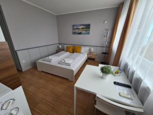 a small room with a bed and a table at Surman Apartmanok in Siófok