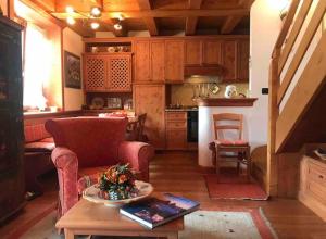 uma cozinha com um sofá e uma mesa num quarto em Mansarda su due livelli nel cuore delle Dolomiti em San Vito di Cadore