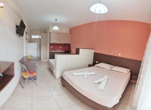 a bedroom with a large bed and a kitchen at Studio Beleri in Himare