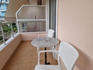a small table and chairs in a balcony with a window at Studio Beleri in Himare