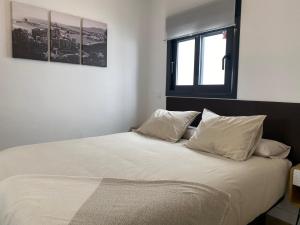 1 dormitorio con 1 cama con sábanas y almohadas blancas en Lovely Private Suite Center, en Málaga