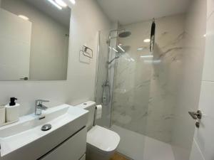 baño blanco con ducha y lavamanos en Lovely Private Suite Center, en Málaga