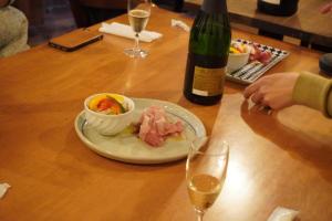una mesa con un plato de comida y una botella de vino en ゲストハウス＆カフェバー　エストアール, en Shibetsu