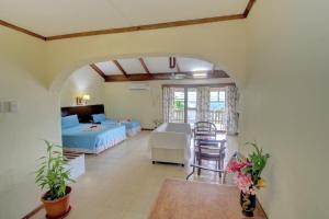 霍尼亚拉Honiara Hotel的一间有床、桌子和椅子的房间