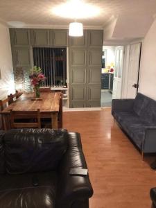 a living room with a black leather couch and a table at Port Lodge Northern Ireland in Portaferry +7 photos
