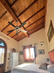 Podere La Branda في فيترالّا: غرفة نوم مع مروحة سقف وسرير