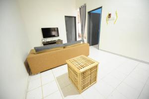 a living room with a couch and a television at Roomstay Rumah Pintu Kuning in Kangar
