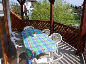 a table and chairs sitting on a porch with a table at Juhász Apartman in Gyenesdiás
