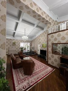sala de estar con sillas de cuero y alfombra en TURAN SEMEY GRAND HOTEL, en Semey