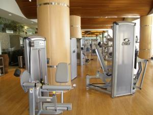 un gimnasio con una fila de cintas de correr y sillas en Beach Club #206A, en Pensacola Beach