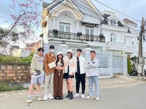 a group of people standing in front of a house at Môn Bạc Home in Da Lat