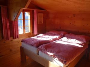 a bedroom with two beds in a wooden cabin at Chalet Buebeberg Ferienhaus mit 8 Betten in Hasliberg Wasserwendi