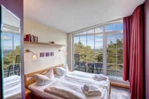 ein Schlafzimmer mit einem Bett und einem großen Fenster in der Unterkunft Ostseeresidenz Gorki- Park - 18 mit Wellness und Schwimmbad in Bansin