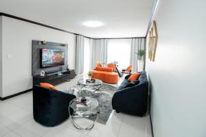 a living room with two couches and a tv at Moonpopson Luxury Apartments, Fourways Sandton in Sandton