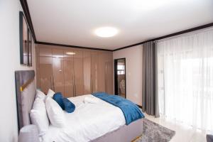 sypialnia z dużym białym łóżkiem i oknem w obiekcie Moonpopson Luxury Apartments, Fourways Sandton w mieście Sandton