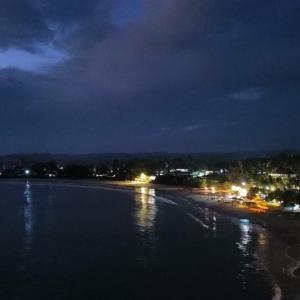 una vista su una spiaggia notturna con luci di Kolition Villa a Dikwella