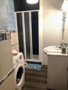 ein Badezimmer mit einer Waschmaschine und einem Waschbecken in der Unterkunft Apartament la Punta de la Móra in La Mora