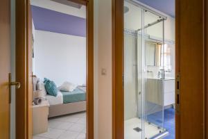 a bathroom with a glass shower and a bedroom at Loft Balcone Sul Mare in Letojanni
