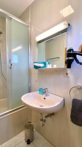 uma casa de banho com um lavatório e um chuveiro em Hotel La Ferté em Estugarda