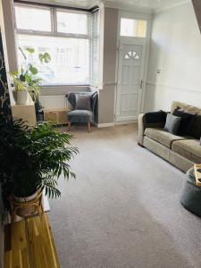 a living room with a couch and a chair at 2 bedroomed house close to Cleethorpes seafront in Cleethorpes