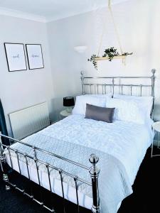 um quarto com uma cama grande e uma colcha branca em 2 bedroomed house close to Cleethorpes seafront em Cleethorpes