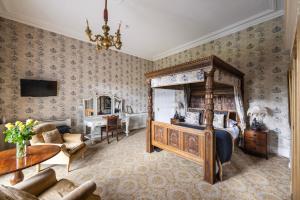 1 dormitorio con cama con dosel y mesa en Belleek Castle, Ballina, en Ballina