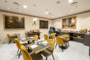 a restaurant with tables and chairs and a counter at Hotel Regina in Milan
