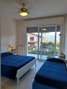 a bedroom with two beds and a large window at Villetta Liana Apuana Mare in Lido di Camaiore