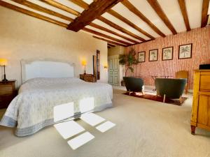 a bedroom with a bed and two chairs at Domaine Des Bidaudieres in Vouvray