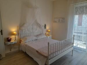 ein Schlafzimmer mit einem weißen Bett und einem Fenster in der Unterkunft Villetta Liana Apuana Mare in Lido di Camaiore