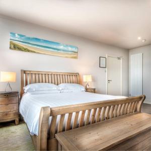 a bedroom with a large bed and a wooden bench at The Woolacombe Bay Hotel in Woolacombe