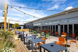 a patio with tables and chairs in a restaurant at Camping Pods Sand Le Mere in Tunstall