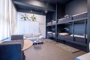 a room with a couch and a table and bunk beds at Hostel Veronika Celje in Celje