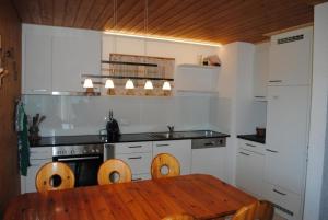 a kitchen with a wooden table and a kitchen with a stove at Chalet Hofer - 5-Bettwohnung in Hasliberg Wasserwendi