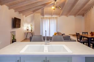 a kitchen with a sink and a living room at Kamari Luxury Apartment in Lefkada Town