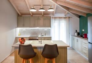 a kitchen with a sink and two bar chairs at Kamari Luxury Apartment in Lefkada Town