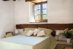 a bedroom with a bed with two pillows and a window at Appartamento Stalla - Cortona in Corgna +11 photos
