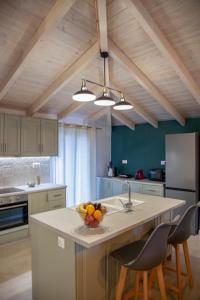 a kitchen with a island with a bowl of fruit on it at Kamari Luxury Apartment in Lefkada Town