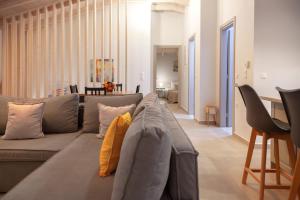 a living room with a gray couch with yellow pillows at Kamari Luxury Apartment in Lefkada Town