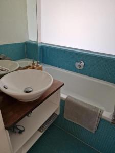 ein Badezimmer mit einem Waschbecken und einer Badewanne mit einem Waschbecken in der Unterkunft Viola 2 Bett Wohnung in Wengen