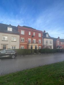a car driving down a street next to houses at Upton Grange Townhouse sleeps 10 in Mollington
