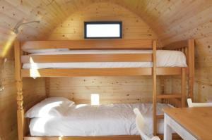 sypialnia z łóżkiem piętrowym w drewnianym domku w obiekcie Camping Pods Sand Le Mere w mieście Tunstall