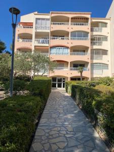 un grand immeuble d'appartements avec une passerelle devant lui dans l'établissement STUDIO SAINT MANDRIER, à Saint-Mandrier-sur-Mer