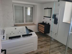 een badkamer met een bad en een glazen douche bij Gites les Gambes in Échenoz-le-Sec