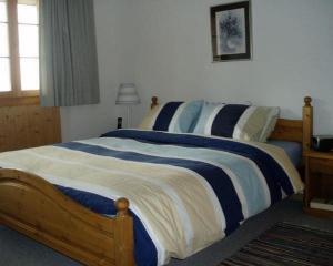 una camera con letto e lenzuola bianche e blu di Pollux 2-Bettwohnung a Hasliberg