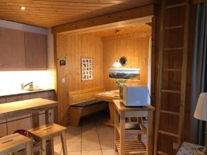 a room with a kitchen with a desk and a microwave at Pollux 2-Bettwohnung in Hasliberg