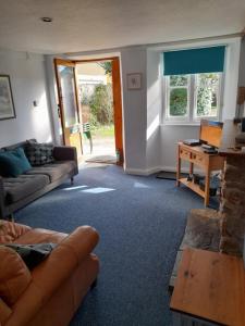 a living room with a couch and a table at 3 Lymbrook Cottage in Lyme Regis